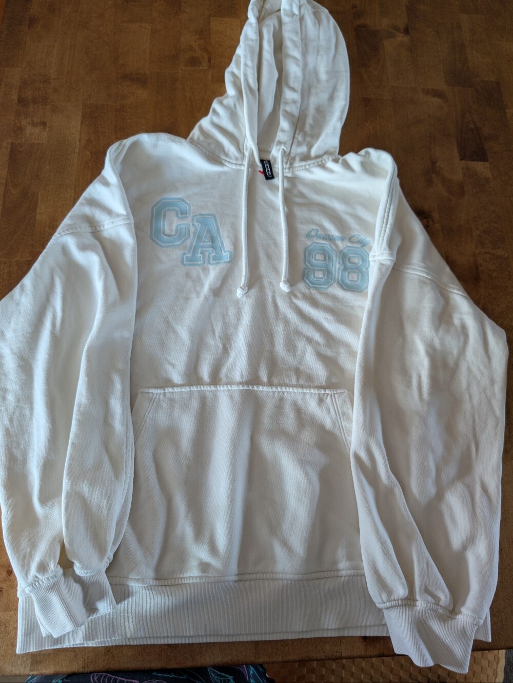 H&M Cream Hoodie with Black Tag and Red Accent